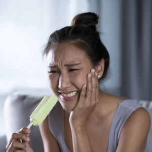 Woman with tooth sensitivity after eating icecream