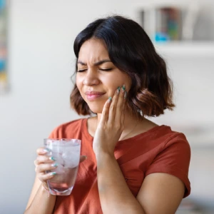 Young woman with tooth sensitivity to cold water